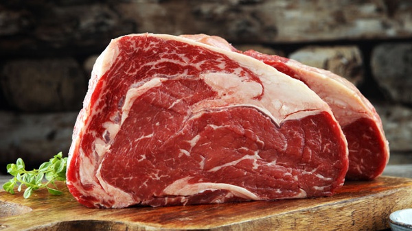 Los 10 alimentos con más creatina (y por qué no bastan para rendir) 11 Corte de carne de vacuno crudo sobre una tabla de madera